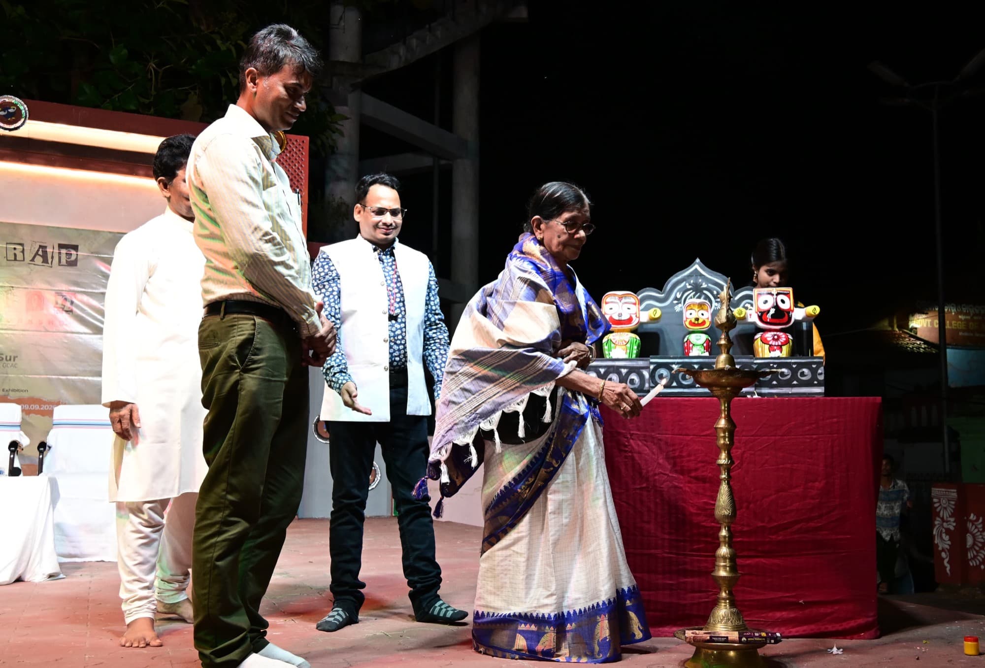 Eminent lady artist Basanta Kumari Samanta lighting the ceremonial lamp before Lord Jagannatha at the From Scrap to Creation paper collage programme of GCAC Khallikote - Image 1