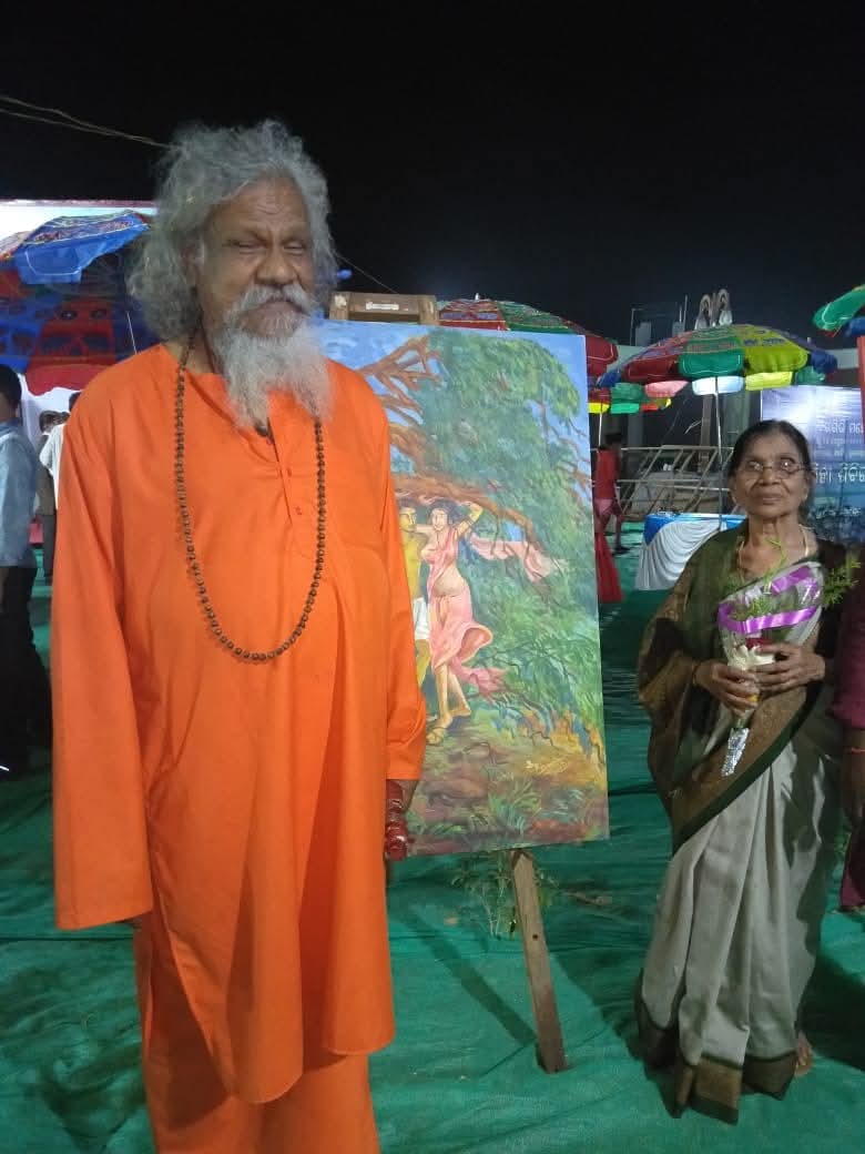 Basanta Kumari Samanta being felicitated with flowers at the Khandagiri-Udayagiri Mahotsav in Bhubaneswar, beside one of her paintings