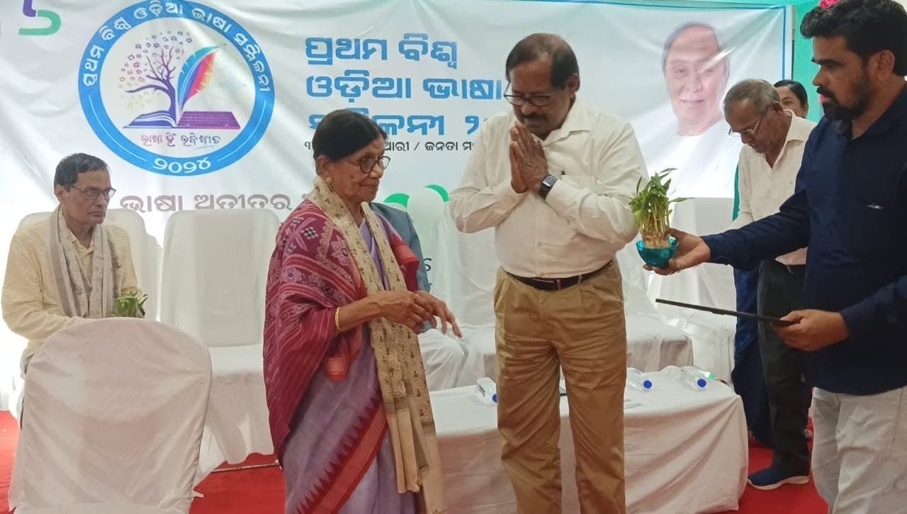Basanta Kumari Samanta being presented a potted plant on stage at the First World Odia Language Conference