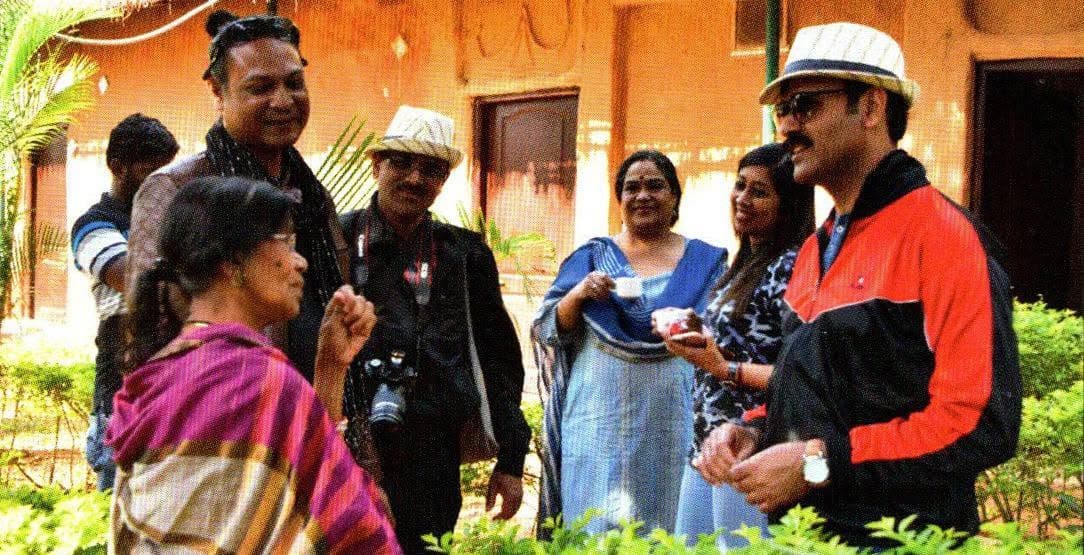 Basanta Kumari Samanta in conversation with a group of visitors and a camera crew outdoors