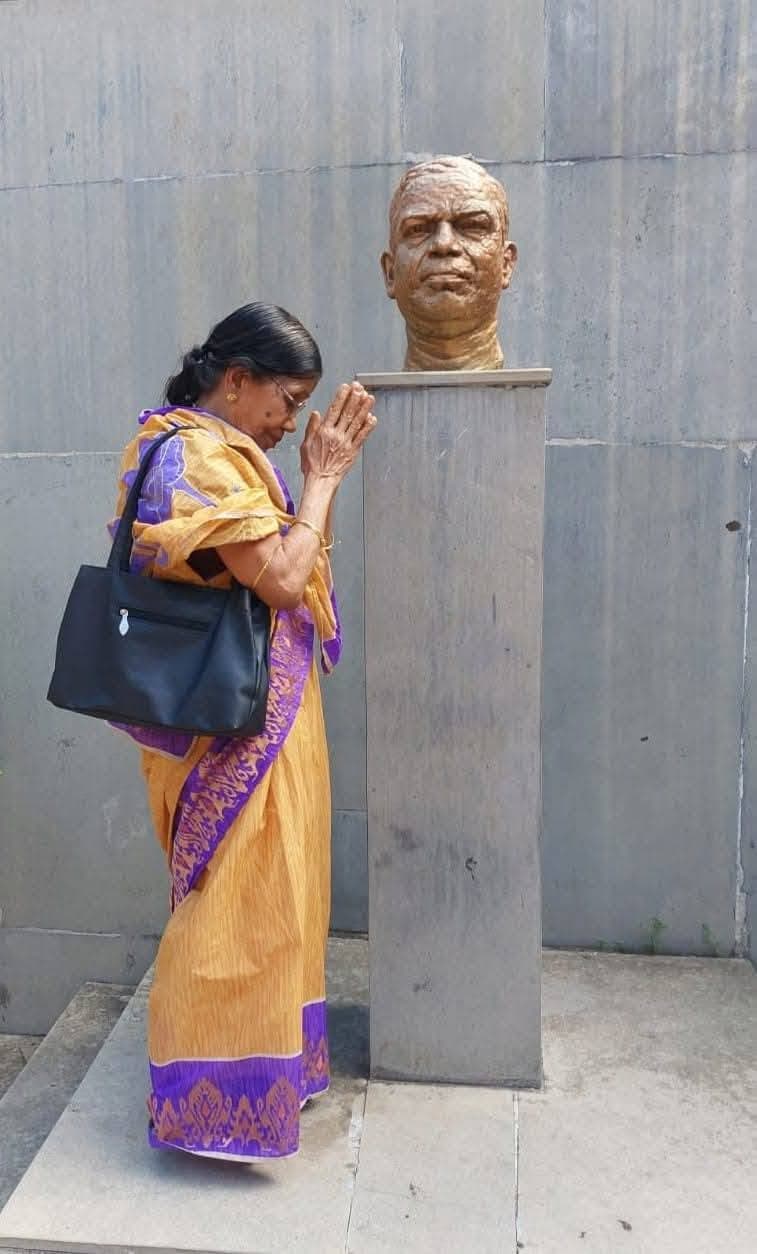 Basanta Kumari Samanta paying homage with folded hands before a bronze memorial bust