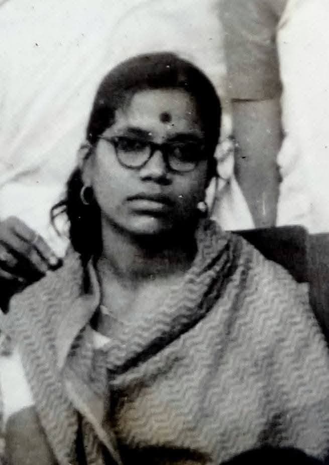 Black and white portrait of a young Basanta Kumari Samanta wearing glasses and a shawl